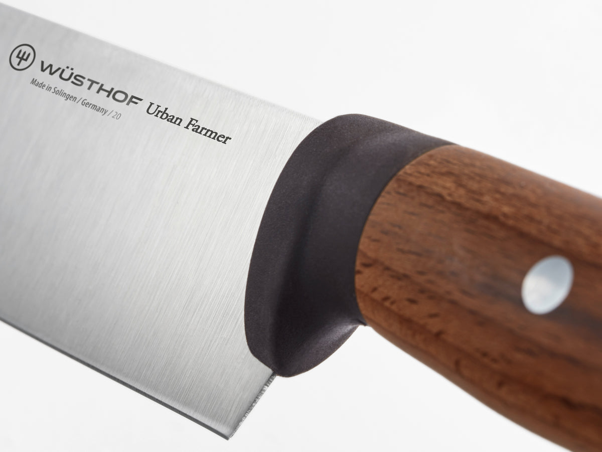 Urban Farmer 7" Chinese Chef's Knife featuring a sharp forged German blade with a smooth wooden handle and ergonomic bolster for balanced kitchen cutting.