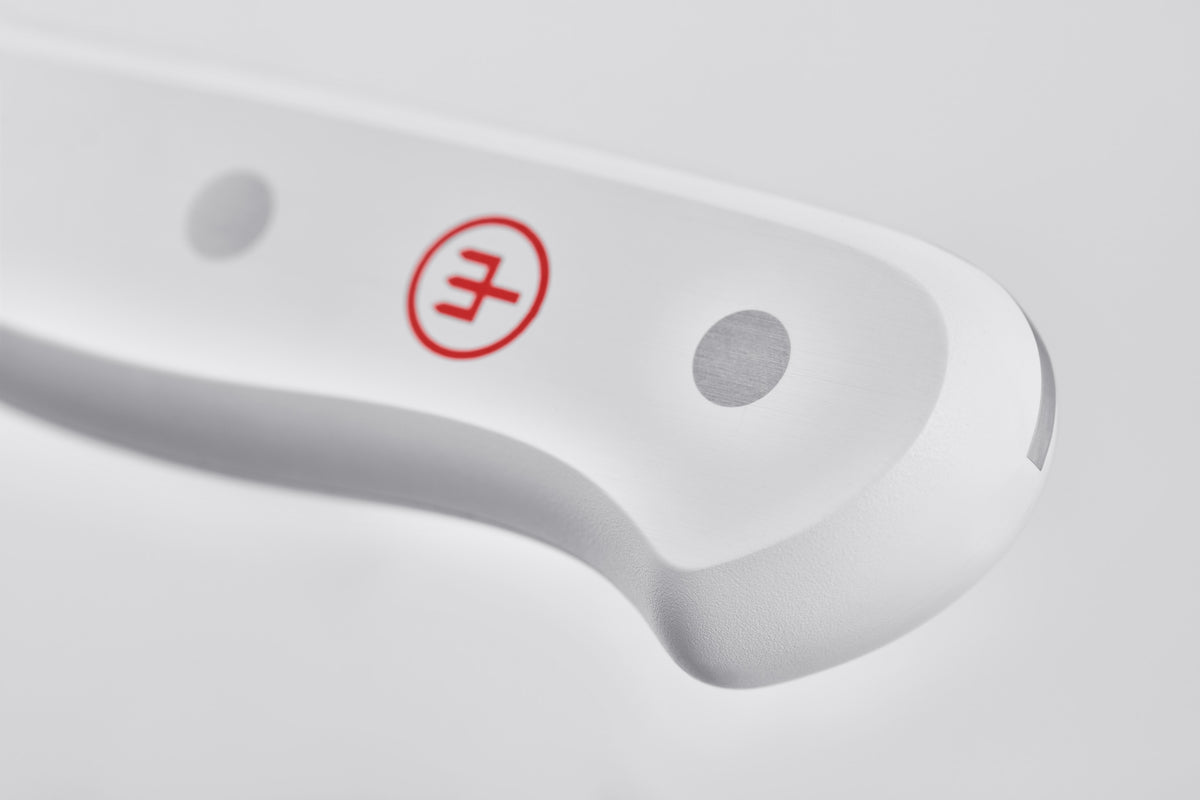 Close-up of the ergonomic white handle with steel rivets and a red logo from the Gourmet 16-Piece Knife Block Set highlighting its sturdy forged design.