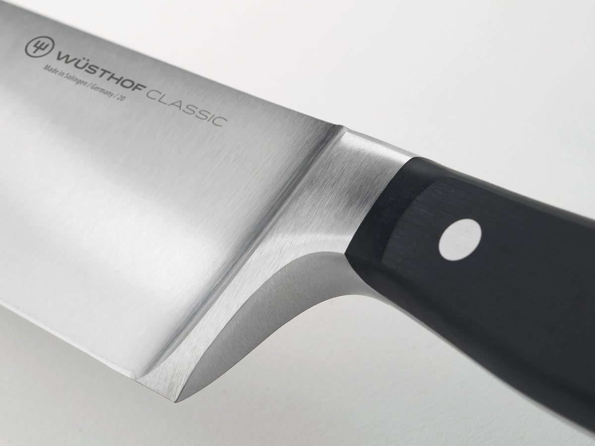 Classic 7-Piece Knife Block Set close-up showing a forged German chef's knife blade with a brushed finish and a black ergonomic handle for balanced control.