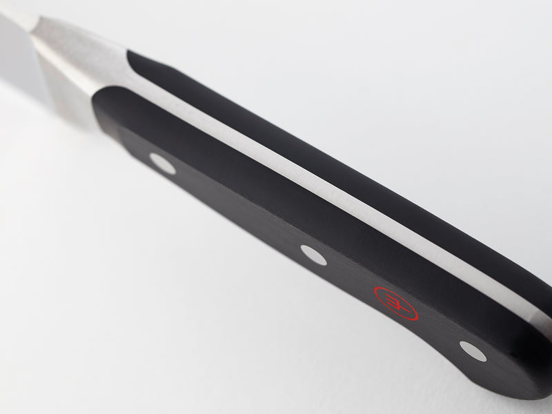 Classic 36-Piece Knife Block Set close-up of a black ergonomic handle with polished rivets on a forged German kitchen knife for balanced grip and control.