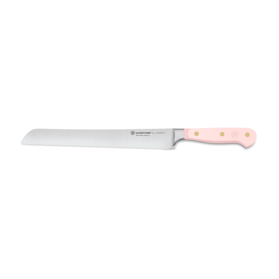Classic 9" Precision Double-Serrated Bread Knife with a finely crafted serrated blade and a pale pink handle featuring triple rivets for durable, comfortable use.