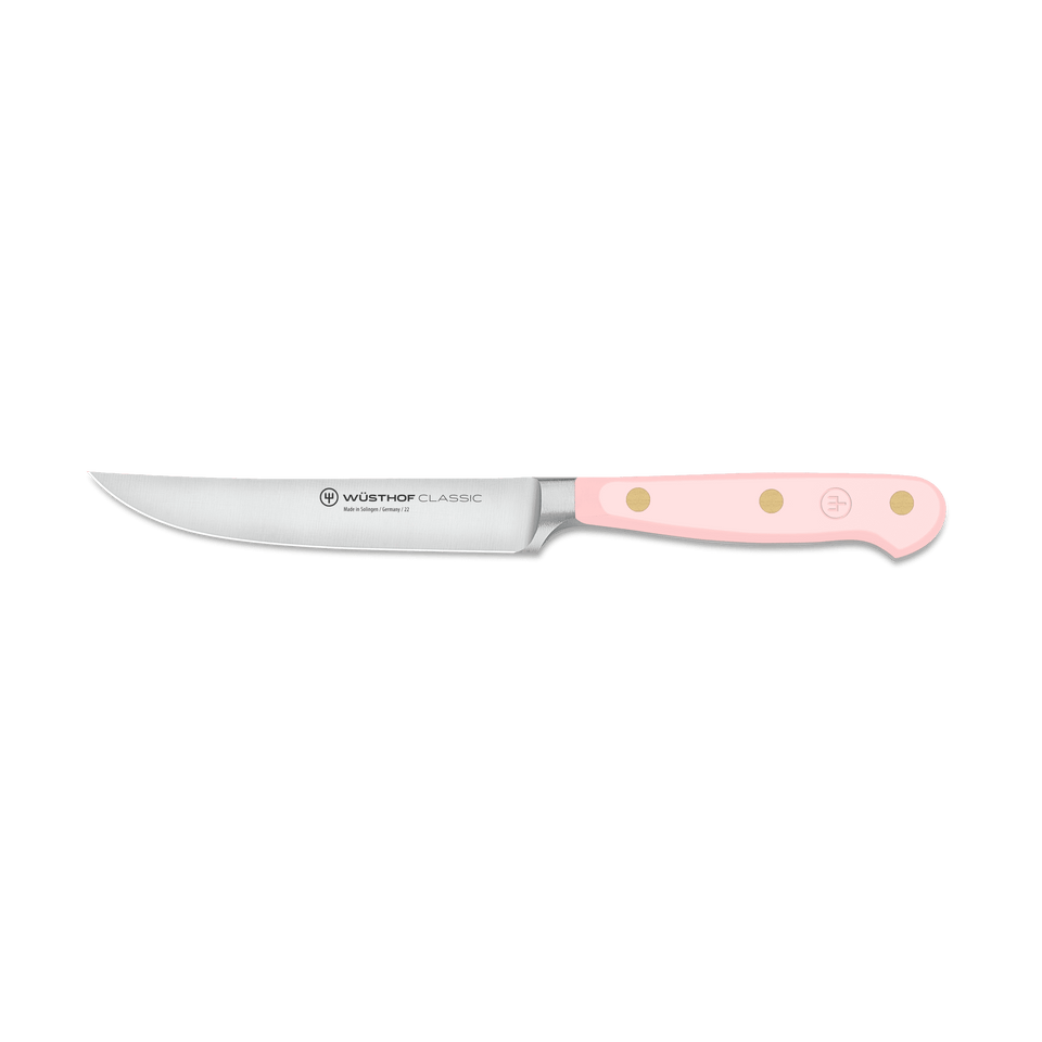 Classic 4 1/2" Steak Knife with a sharp stainless steel blade and a smooth pale pink handle secured by three brass rivets for durability and style.