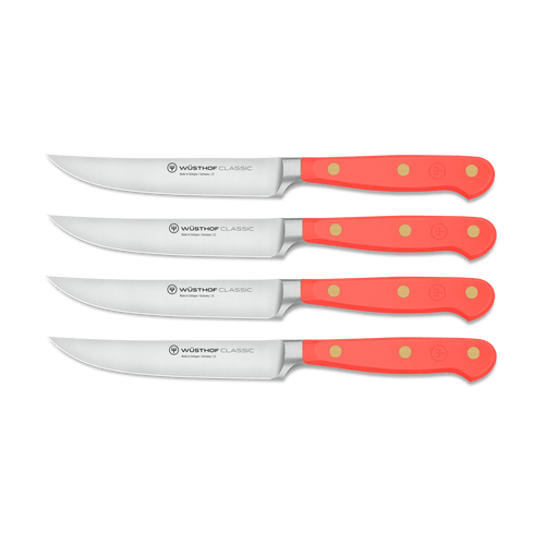 Classic 4-Piece Steak Knife Set featuring forged German steel blades and bright orange triple-riveted handles for a secure, ergonomic grip.
