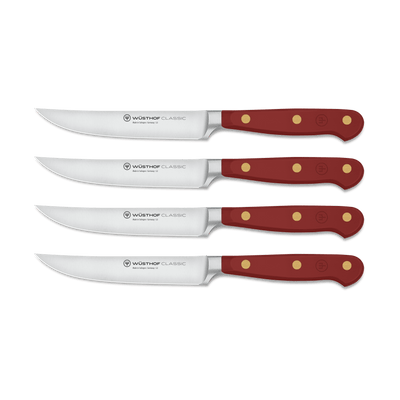 Classic 4-Piece Steak Knife Set featuring sharp curved stainless steel blades with full tang construction and deep red handles secured by three brass rivets.