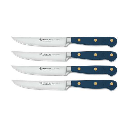 Classic 4-Piece Steak Knife Set featuring navy blue triple-riveted handles with polished brass rivets and sharp full tang forged German steel blades.