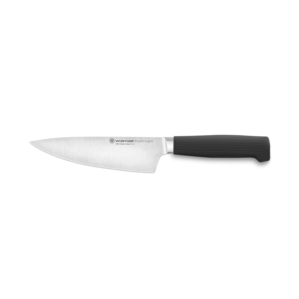 Partner 6” Chef’s Knife featuring a sharp forged German blade and a black ergonomic handle designed for precise cutting and comfortable grip.
