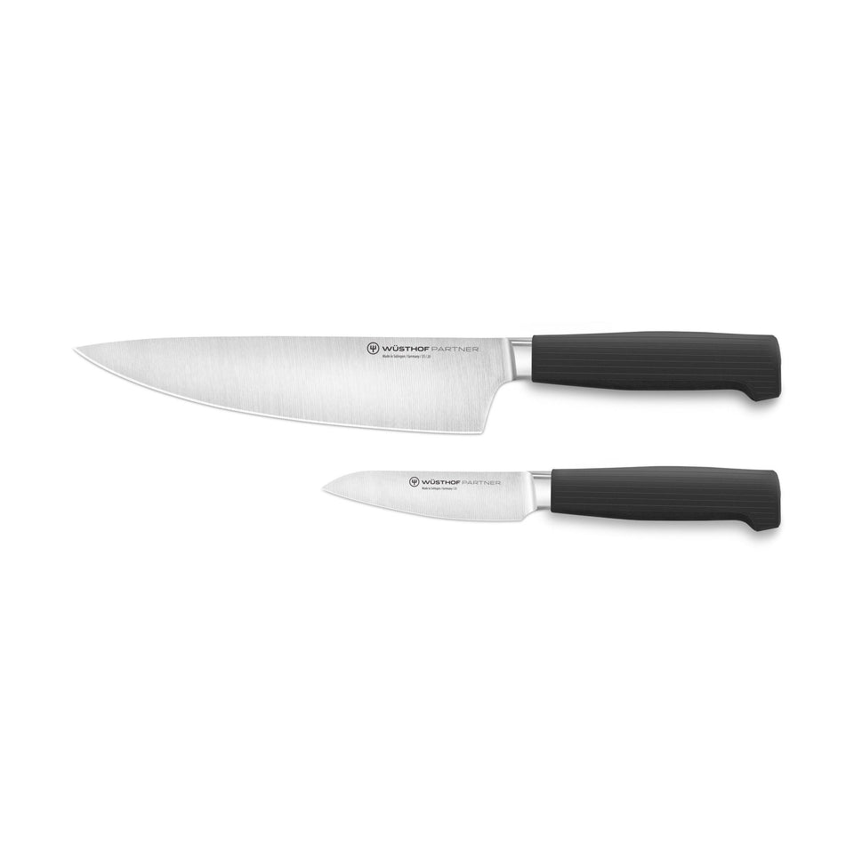 Partner 2-Piece Knife Set featuring a forged German blade chef’s knife and paring knife with textured black ergonomic handles for versatile kitchen use.