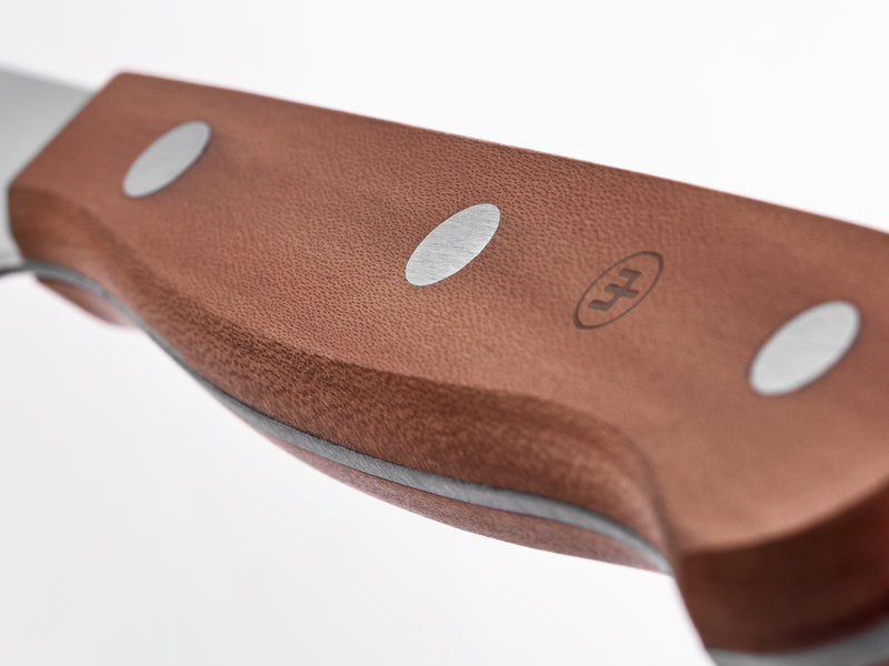 Close-up view of the textured plum wood handle with polished steel rivets and tang on the 4 1/2" Plum Wood Steak Knife.