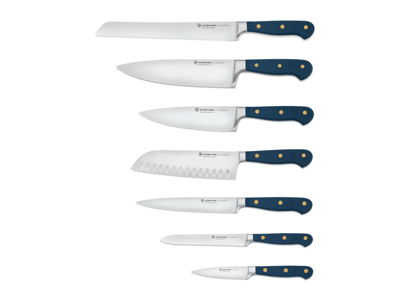 Classic 8-Piece Designer Knife Block Set featuring six forged German steel knives with deep blue ergonomic handles and brass rivets, including serrated and chef’s knives.
