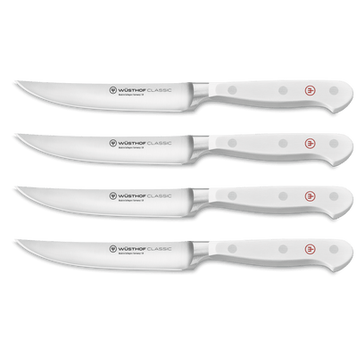 Classic 4-Piece Steak Knife Set with white ergonomic handles featuring triple rivets and sharp German-forged blades for precise slicing.