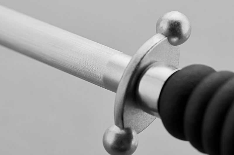 12" Honing Steel featuring a polished steel rod and protective cross guard with rounded ends, paired with a textured black handle for knife sharpening.