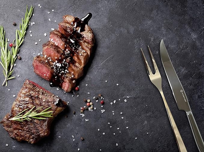 2-Piece Stainless Steel Gift Set featuring a polished carving knife and fork with sleek handles displayed next to sliced steak seasoned with coarse salt and pepper.
