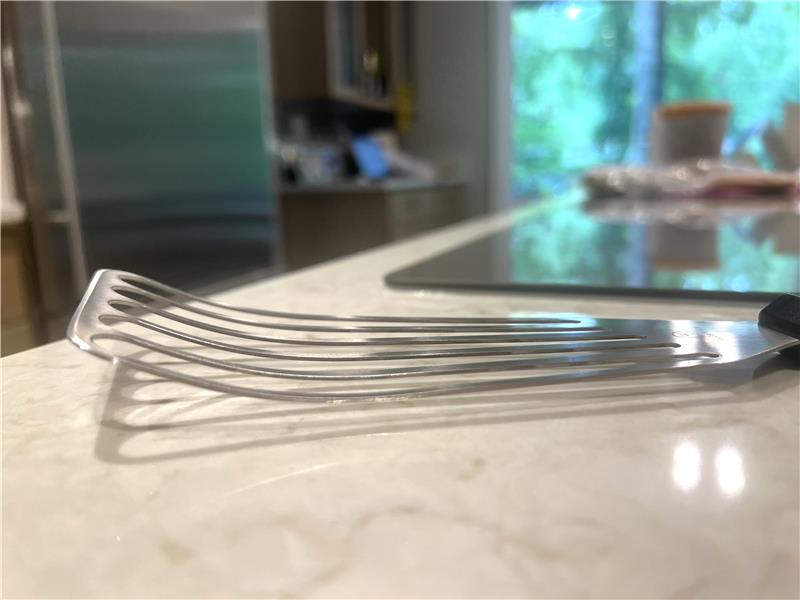 Metal spatula on a kitchen counter with a blurred background