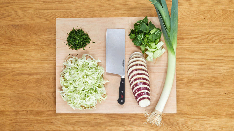 Classic 2-Piece Asian Knife Set featuring a forged German cleaver with a sharp stainless steel blade and black handle, displayed with chopped vegetables.