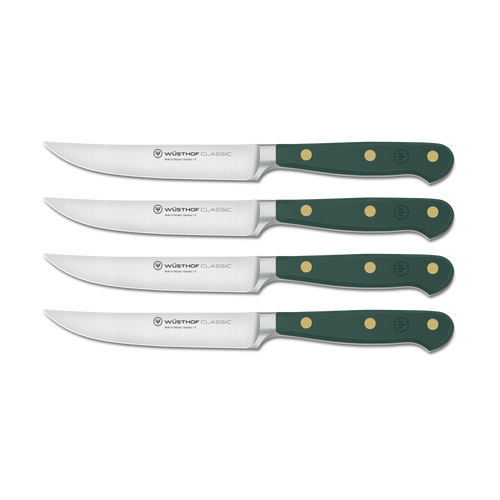 Set of four Wusthof Classic steak knives with green handles on a white background