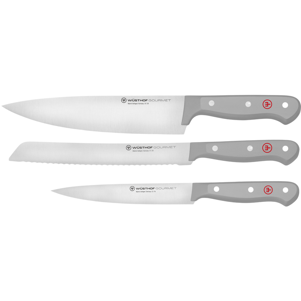 Three forged German kitchen knives with sleek grey handles, including a chef's knife, bread knife, and paring knife from the Gourmet Grey 3-Piece Starter Set.
