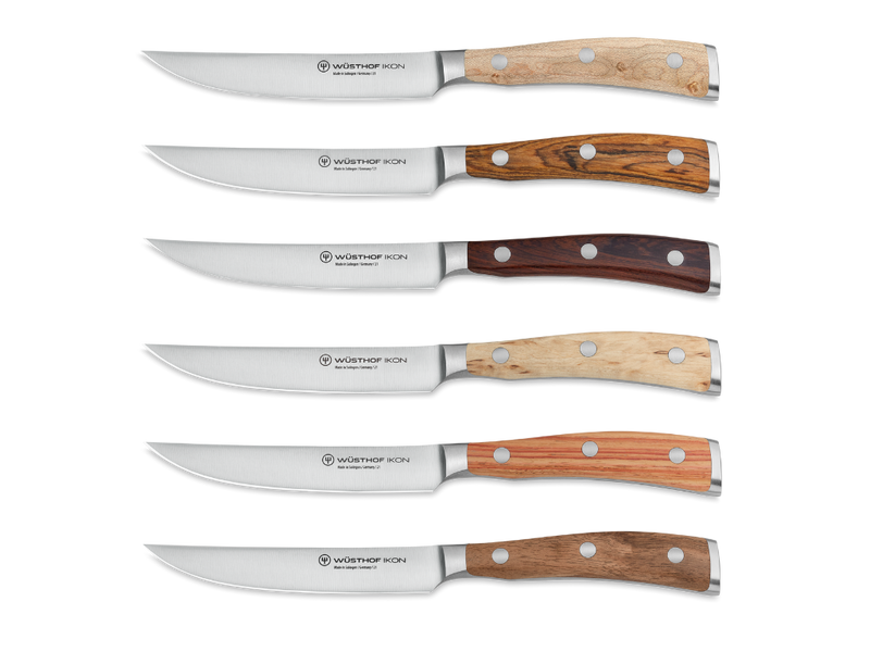 Ikon 6-Piece Mixed Wood Steak Knife Set with Leather Knife Roll displaying six WÜSTHOF forged German steak knives, each featuring distinct mixed wood handles.