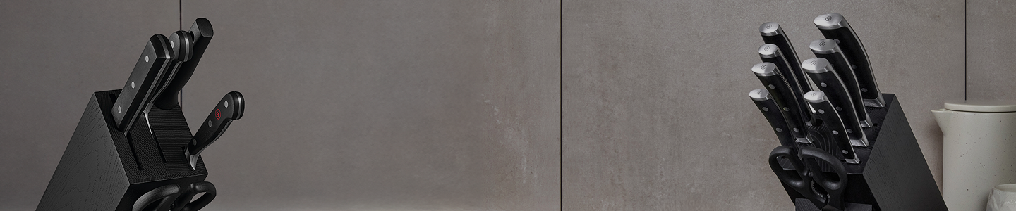 Black knife block with knives on a gray background
