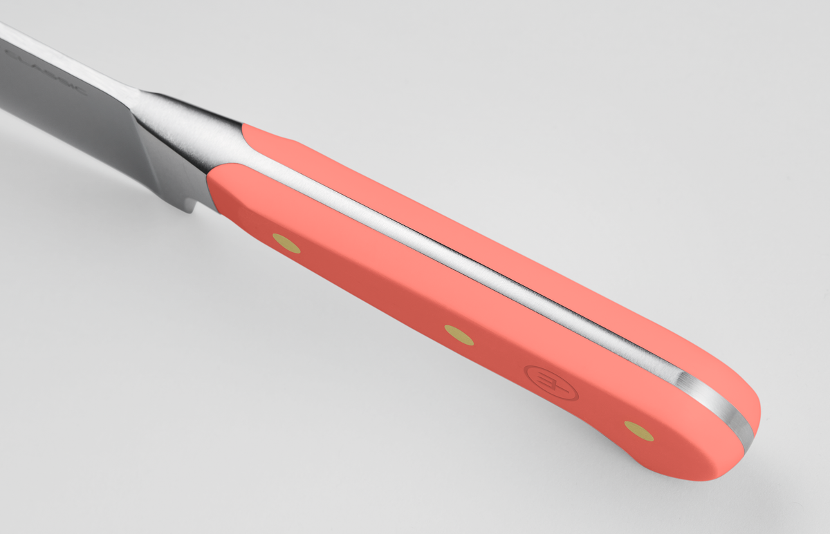 Classic 7" Hollow Edge Santoku featuring a bright coral handle with triple rivets and a polished steel tang for sturdy, balanced grip and precision.