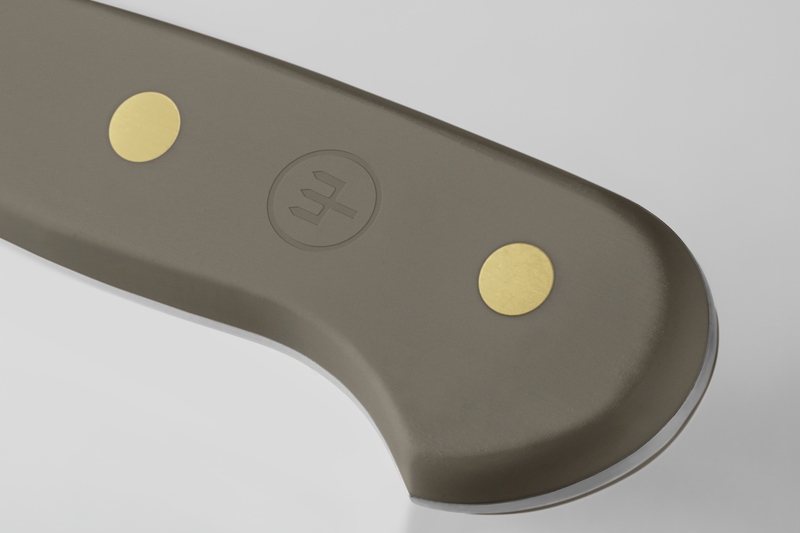 Handle detail of the Classic 9" Precision Double-Serrated Bread Knife showing a taupe ergonomic grip with brass rivets and subtle embossed logo.