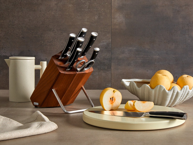 Classic Ikon 9-Piece Knife Block Set with forged German knives featuring full tang stainless steel handles in a rich wooden block with stainless steel stand, displayed with sliced apples.