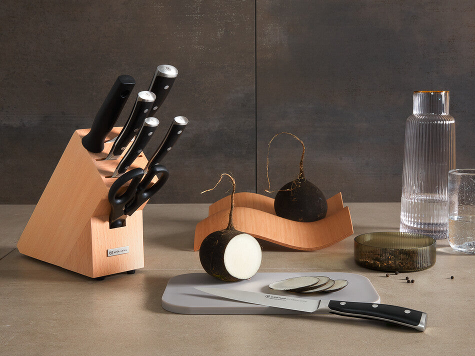 Classic Ikon 8-Piece Starter Knife Block Set featuring forged German knives with polished stainless steel blades and black ergonomic handles in a light wood block.