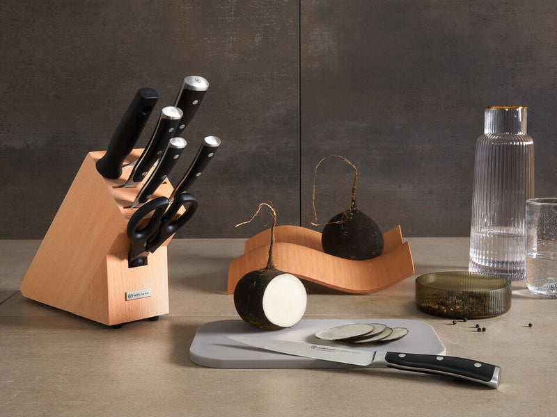 Classic Ikon 8-Piece Starter Knife Block Set featuring forged German knives with polished stainless steel blades and black ergonomic handles in a light wood block.