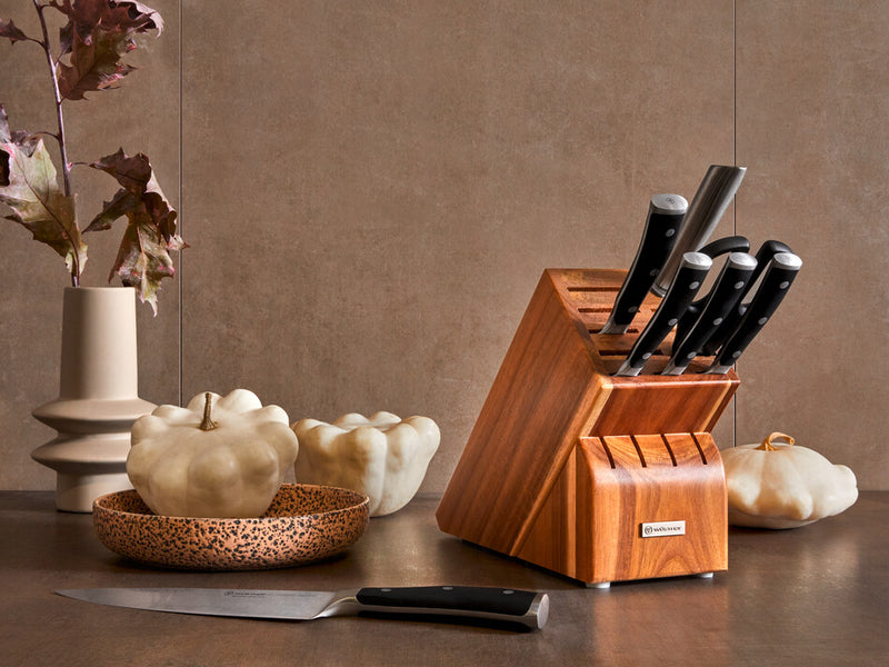 Classic Ikon 8-Piece Knife Block Set showcasing a wooden block with forged German stainless steel knives featuring black ergonomic handles in a kitchen setting.