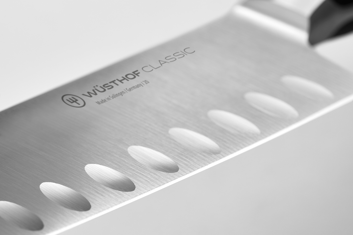 Classic 7" Hollow Edge Santoku featuring a forged German steel blade with scalloped indentations for reduced food sticking and improved slicing precision.