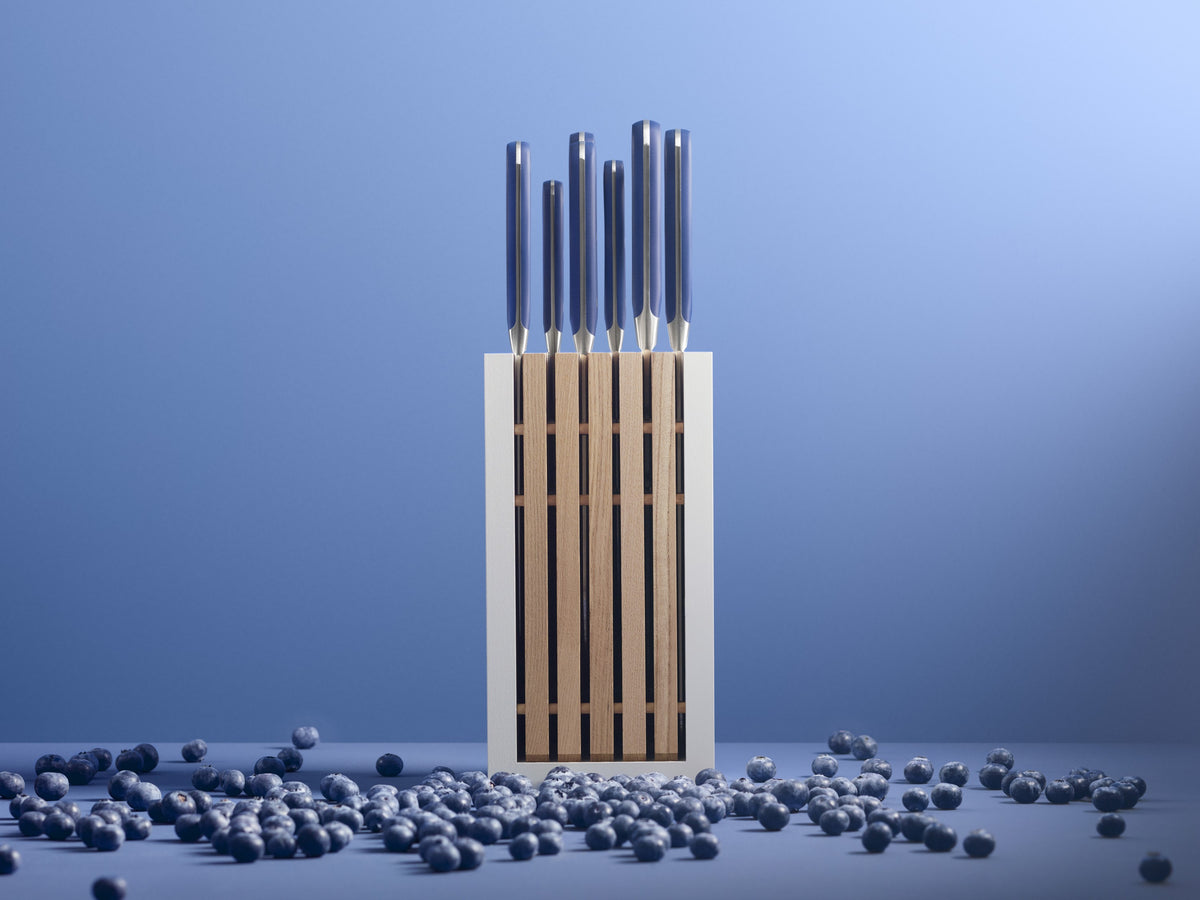Classic 8-Piece Designer Knife Block Set featuring sleek, polished metal handles with a modern white and wooden block amid scattered blueberries.