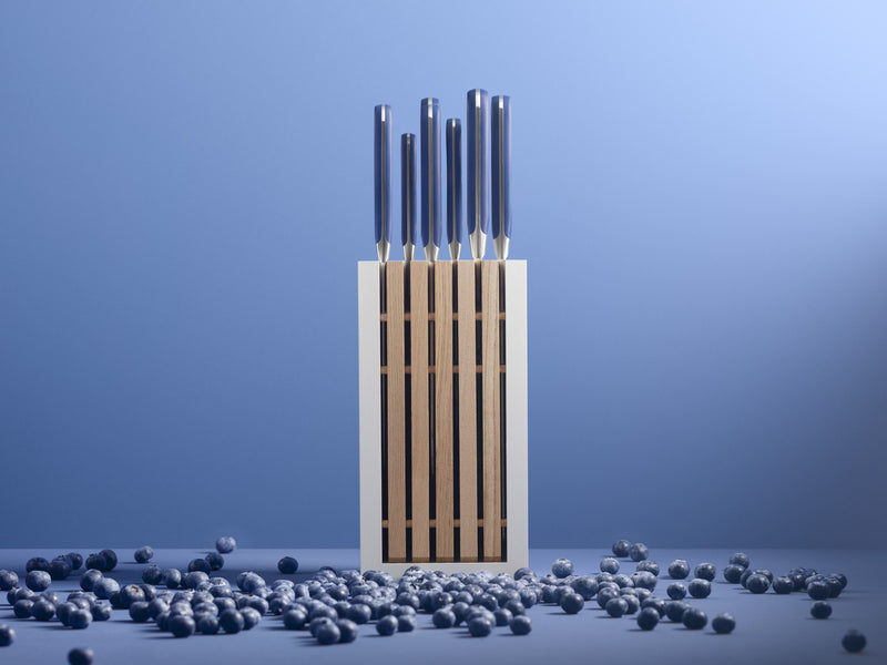 Classic 8-Piece Designer Knife Block Set featuring sleek, polished metal handles with a modern white and wooden block amid scattered blueberries.