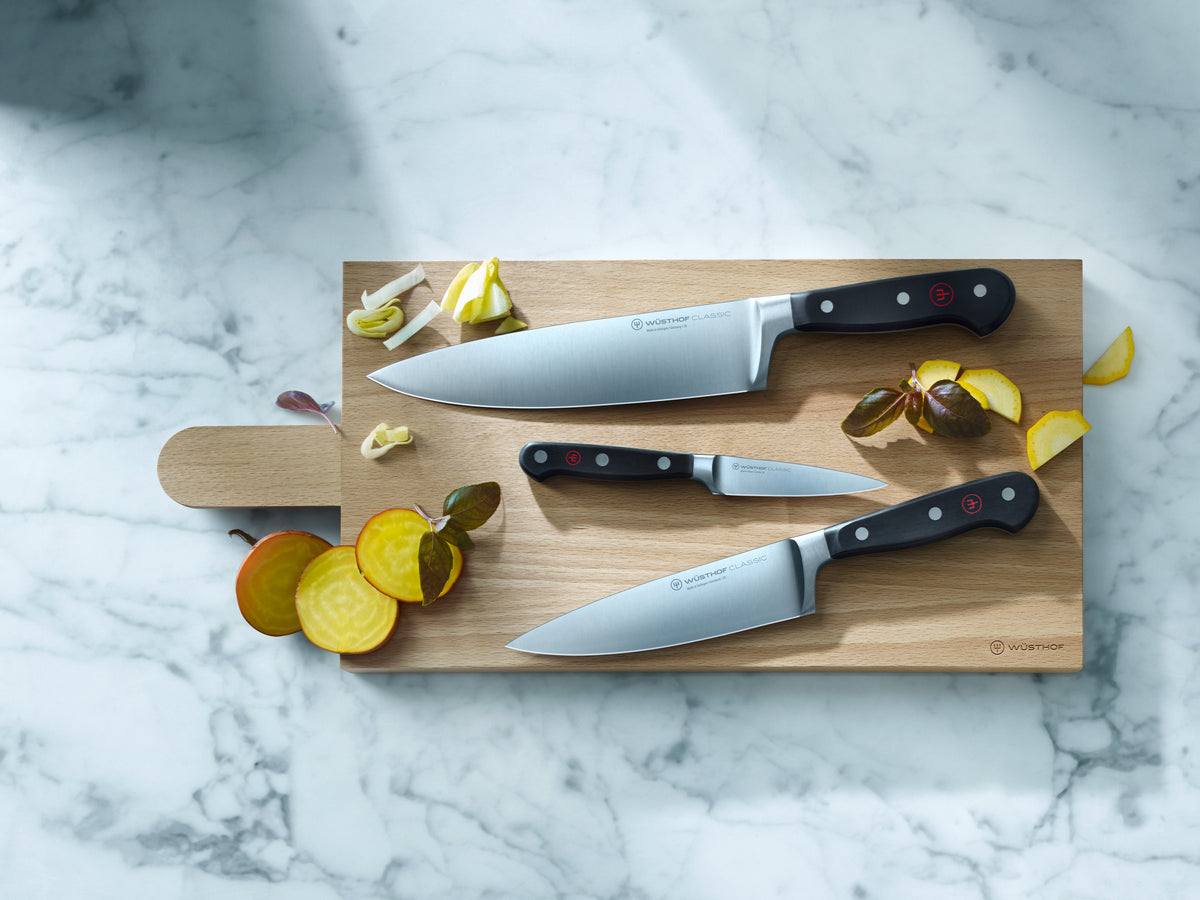 Classic 6" Chef's Knife with a full tang German forged blade and ergonomic black handle featuring triple rivets and a red emblem for balance and precision.