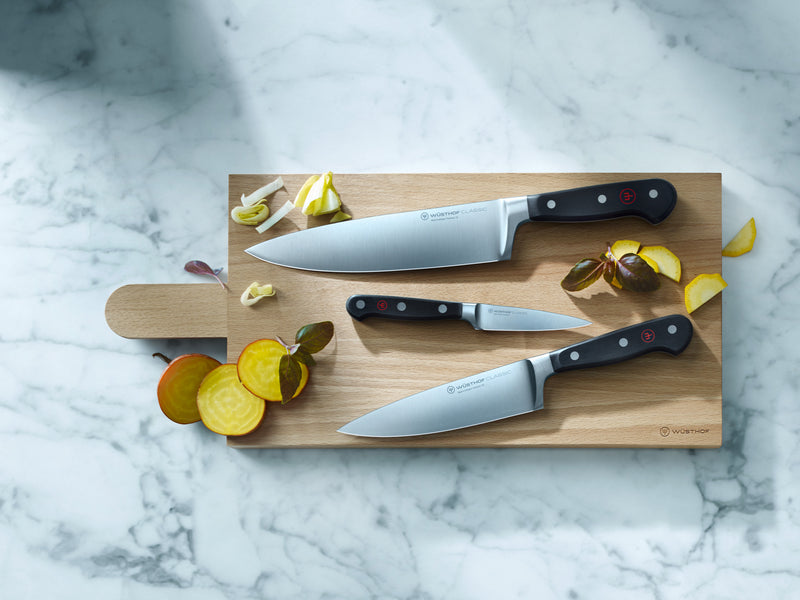 Classic 6" Chef's Knife with a full tang German forged blade and ergonomic black handle featuring triple rivets and a red emblem for balance and precision.