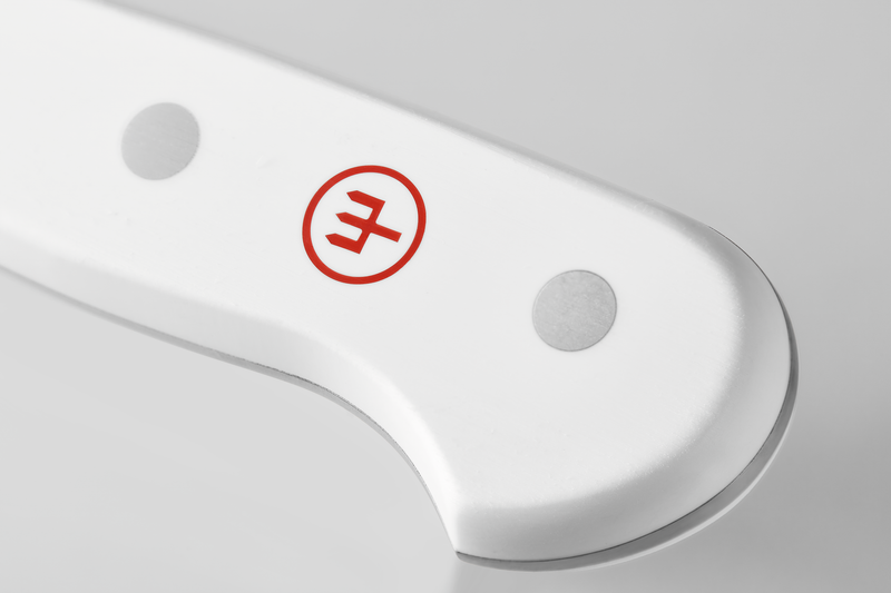 Close-up of the smooth white handle of the Classic 3 1/2" Paring Knife, featuring two stainless steel rivets and a red logo emblem.