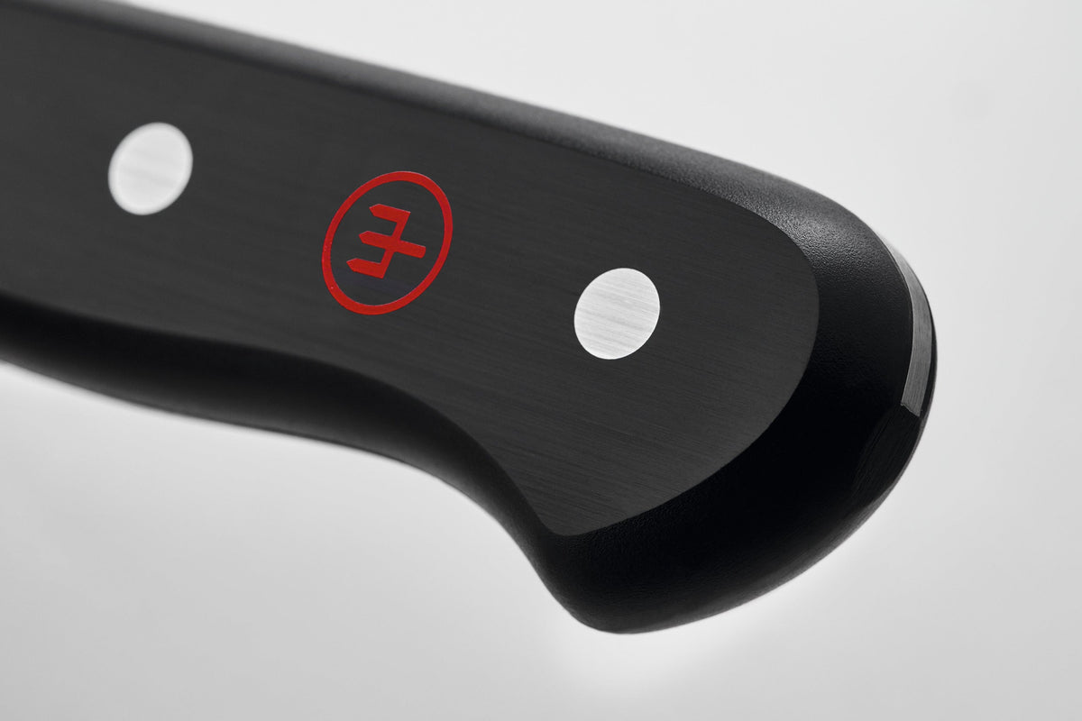 Close-up of the black ergonomic handle with polished steel rivets and red logo on a forged German knife from the Gourmet 16-Piece Knife Block Set.
