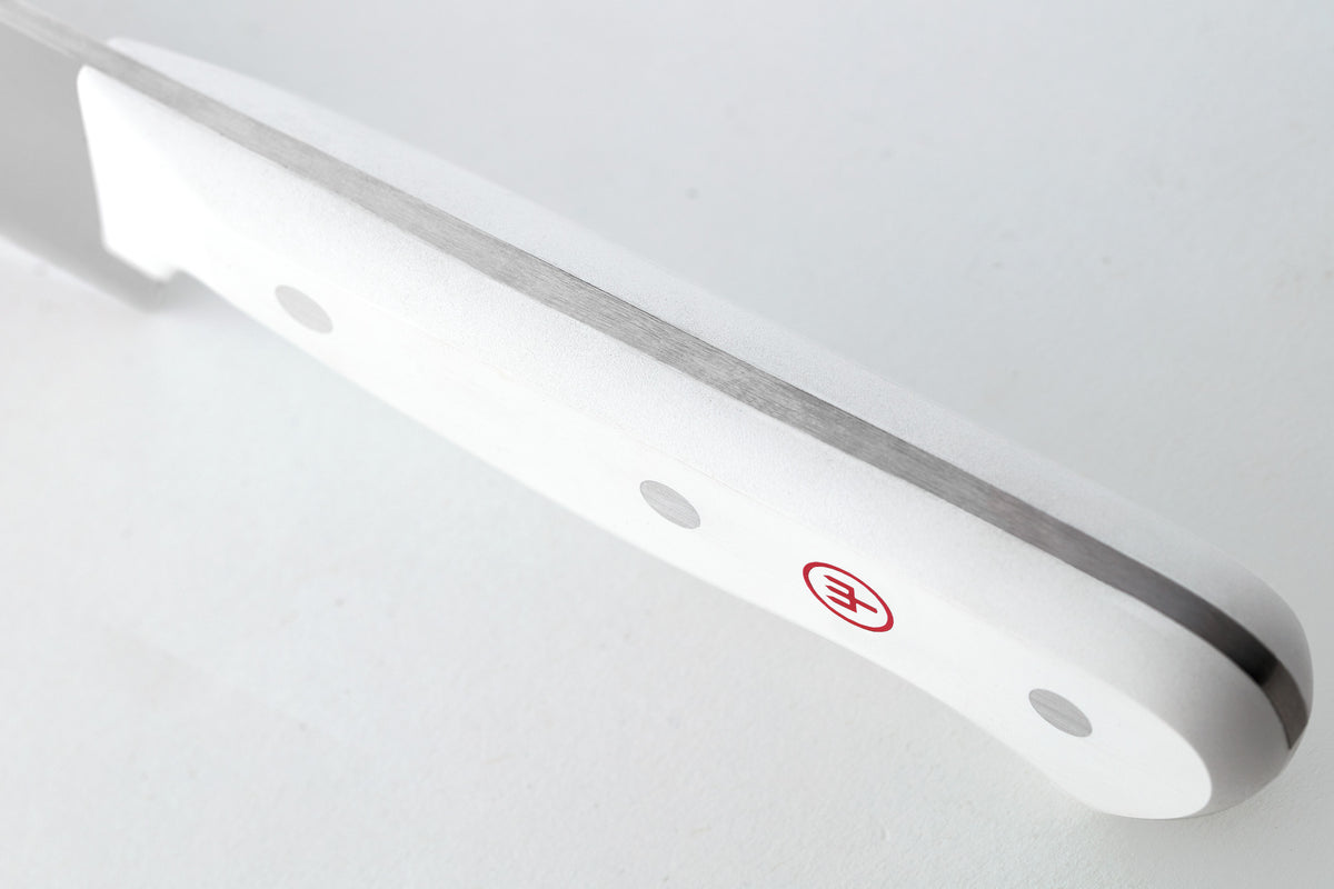 Close-up of the full tang construction and smooth white handle with rivets and red logo from the Gourmet 16-Piece Knife Block Set.