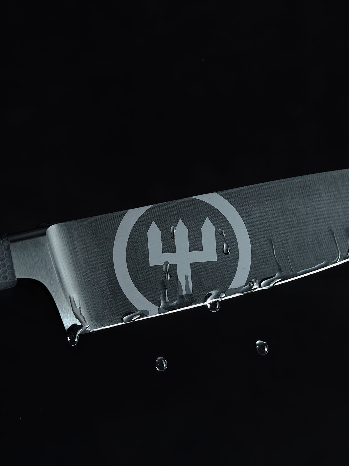 Performer 6" Chef's Knife blade close-up with water droplets highlighting its sharp edge and brushed forged German steel construction.