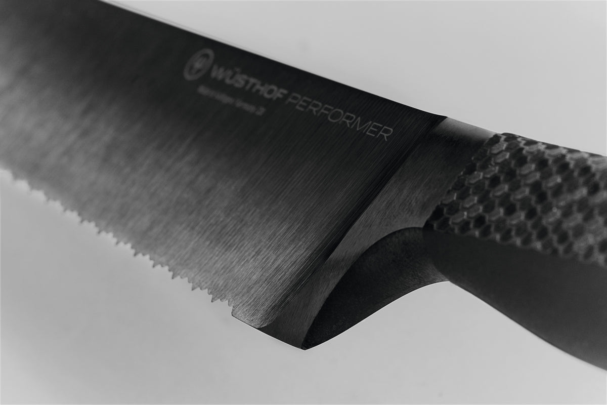Close-up of the forged blade and textured ergonomic handle on the Performer 9" Precision Double-Serrated Bread Knife highlighting its sleek design for precision cutting.
