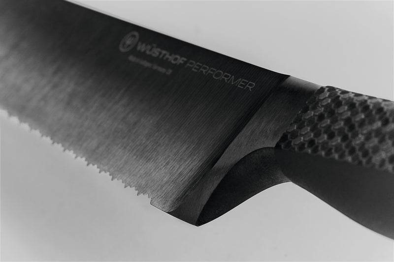 Close-up of the forged blade and textured ergonomic handle on the Performer 9" Precision Double-Serrated Bread Knife highlighting its sleek design for precision cutting.