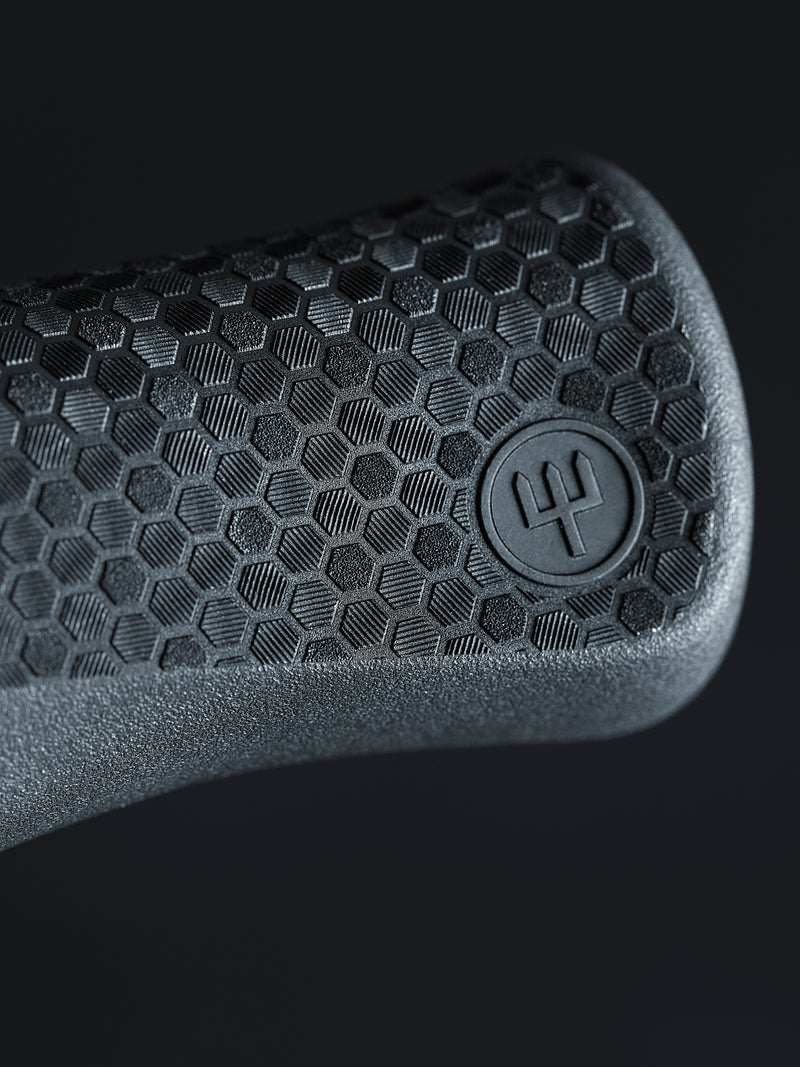 Performer 6" Chef's Knife textured black handle close-up with hexagonal pattern and embossed logo for enhanced grip and control.