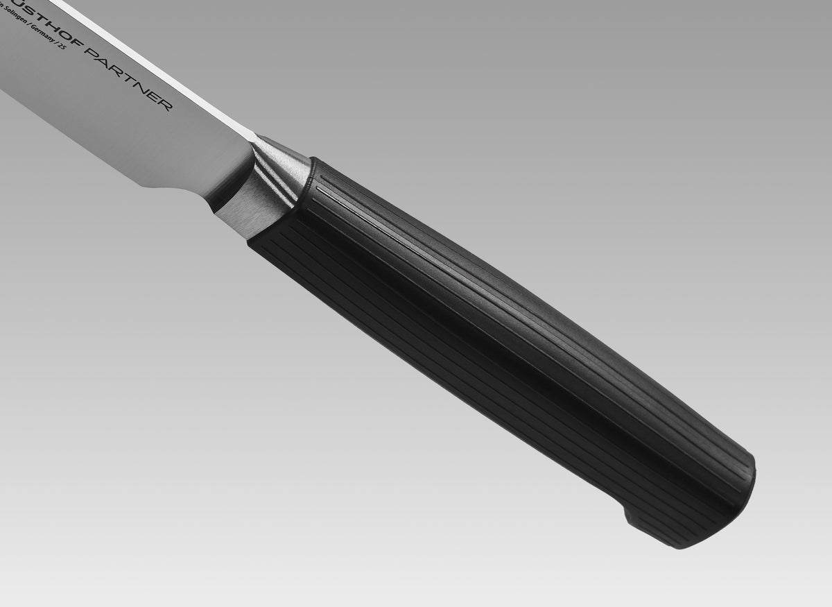 Partner 7-Piece Knife Block Set featuring a close-up of a forged German blade with a textured black ergonomic handle designed for precision and durability.