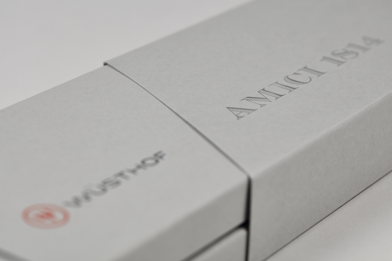 Minimalist and elegant gray packaging box embossed with "AMICI 1814" and the WÜSTHOF logo, designed for the Amici 1814 forged kitchen knife.
