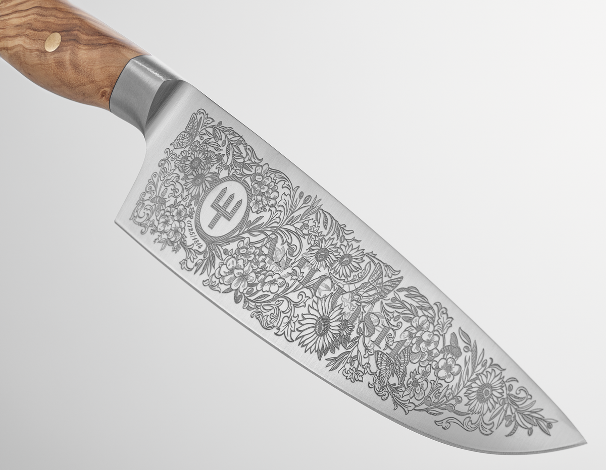 Amici 1814 forged kitchen knife with an elaborately engraved floral design on the blade and a smooth olive wood handle with brass rivets.