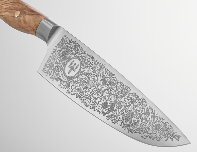 Amici 1814 forged kitchen knife with an elaborately engraved floral design on the blade and a smooth olive wood handle with brass rivets.