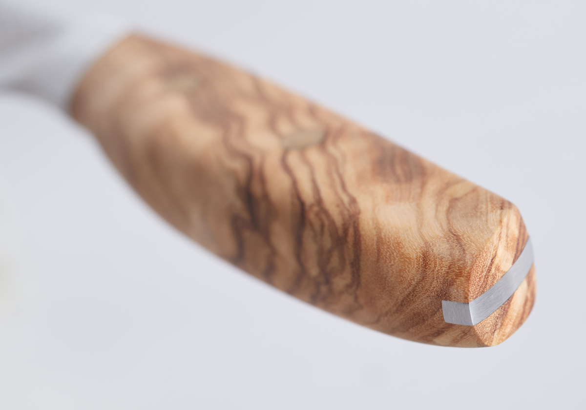 Amici 1814 kitchen knife handle crafted from smooth olive wood with a natural grain pattern and a polished metal end cap.