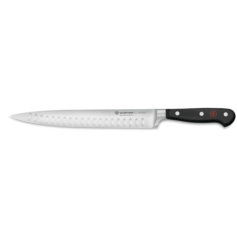 Classic 9" Hollow Edge Carving Knife featuring a forged German steel blade with scalloped indentations and a black ergonomic handle secured by three rivets.
