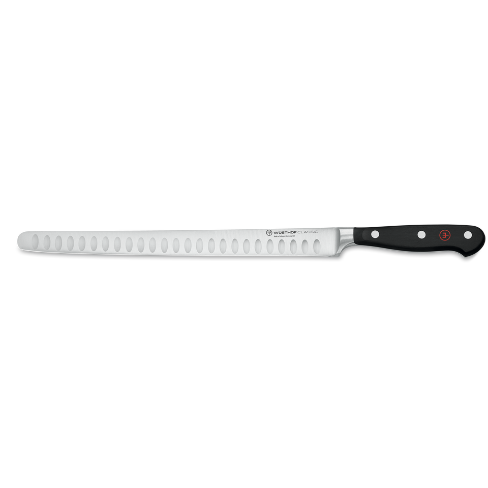 Classic 10" Hollow Edge Ham Slicer with a long, narrowly forged stainless steel blade featuring oval indentations and a black triple-riveted handle for smooth slicing.