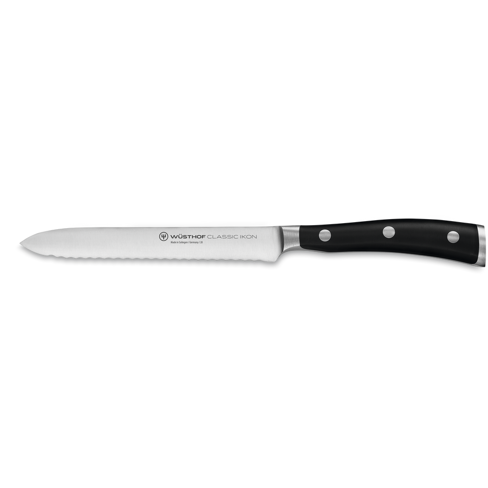 Classic Ikon 5" Serrated Utility Knife with a sharply serrated German forged steel blade and a triple-riveted black handle for versatile kitchen tasks.