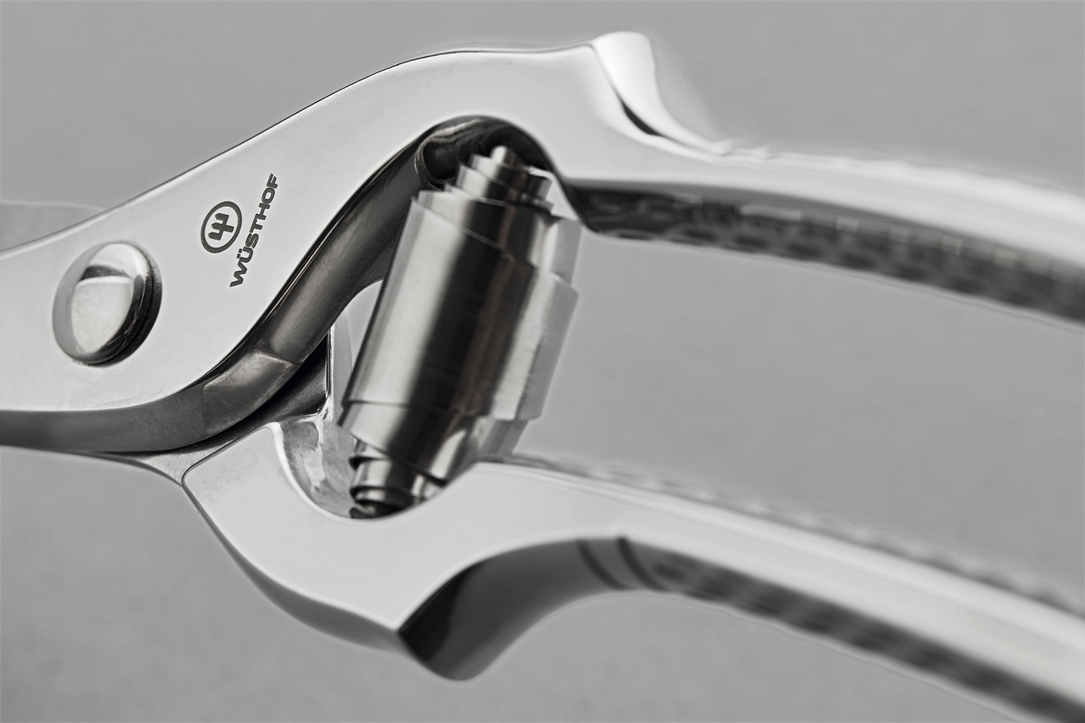 Close-up of the polished joint and spring mechanism on the 10" Stainless Steel Poultry Shears with durable metal construction and precision cutting edges.