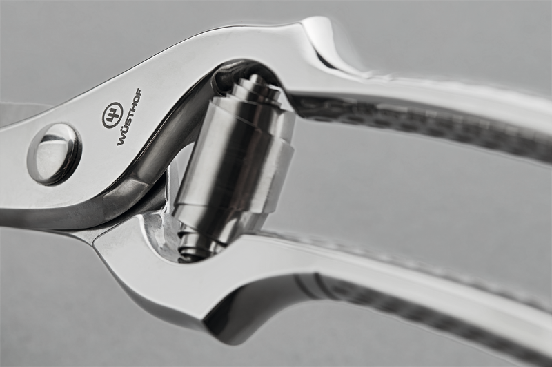 Close-up of the polished joint and spring mechanism on the 10" Stainless Steel Poultry Shears with durable metal construction and precision cutting edges.